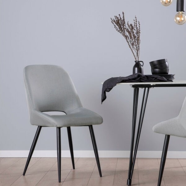 La silla de comedor Emily en tapizado gris con asiento de respaldo alto y forma ergonómica es uno de nuestros diseños con más personalidad. Cualquiera de las 3 tonalidades de sus acabados
