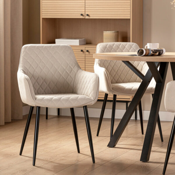 Las silla de comedor tapizada Lizel con pata metálica negra es una apuesta por el confort gracias a su forma ergonómica con reposabrazos integrado. Su acabado en poliéster con dibujo en rombos está disponible en 2 colores