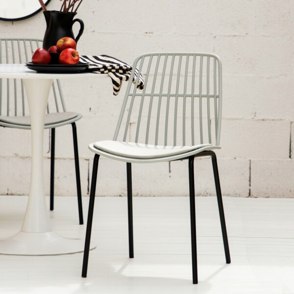 La silla de comedor Erica con patas metálicas en color negro es una preciosa pieza de estilo moderno con respaldo de rejilla fabricado en poliéster