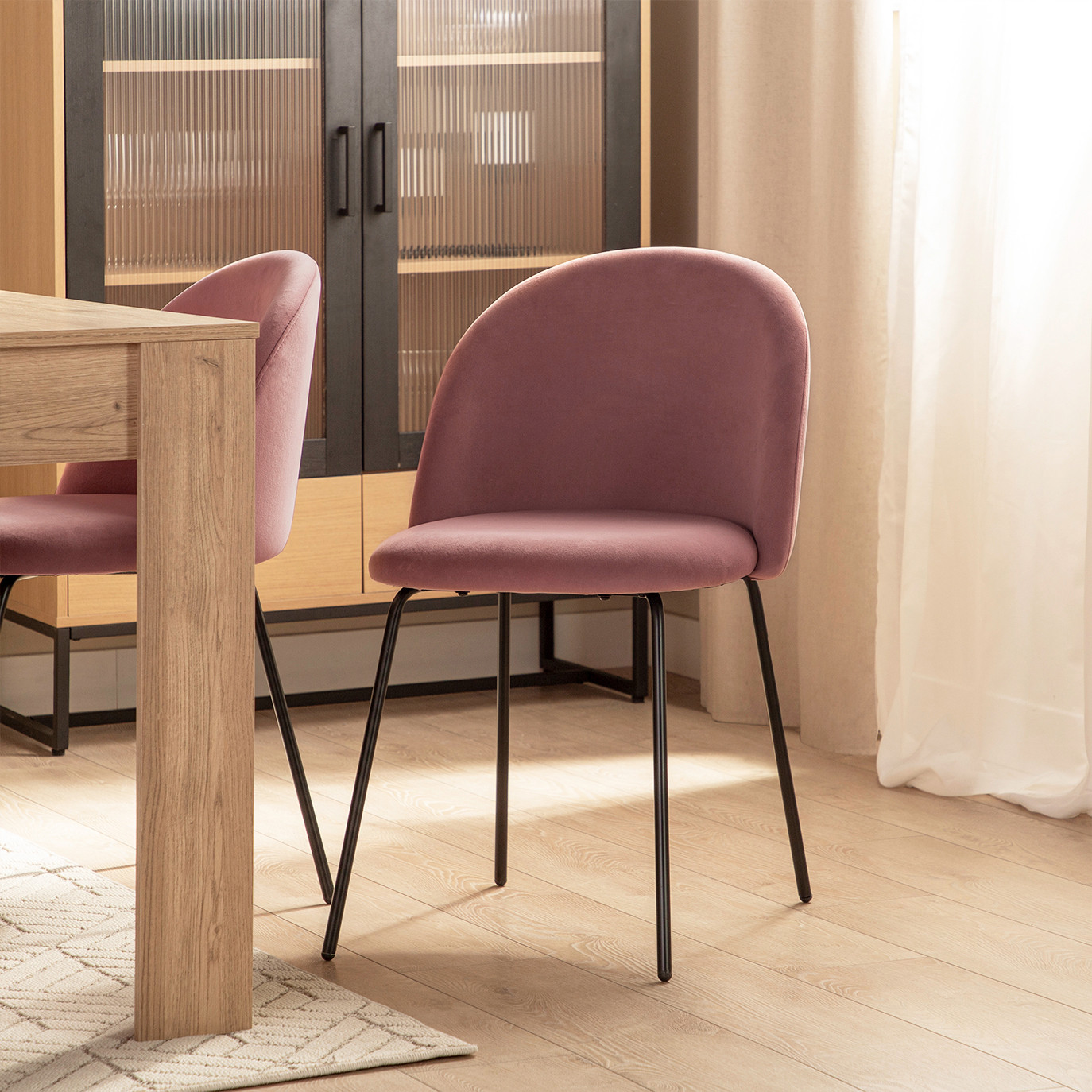 La silla de comedor Olivia en terciopelo rosa y pata metálica negra tiene un diseño elegante y sencillo inspirado en los años 50. Su respaldo corto y redondeado unido al diseño de sus patas cónicas despuntadas recuerdan a esos modelos de sillería sofisticados y funcionales adaptables a cualquier estilo.