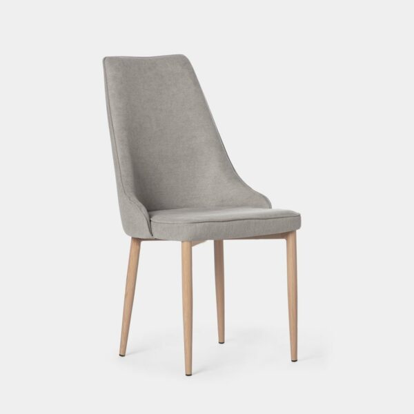 La silla de comedor Agnes tapizada en gris con pata natural presenta un diseño con un aire vintage y líneas completamente atemporales. Además de aportar elegancia y personalidad a tu comedor
