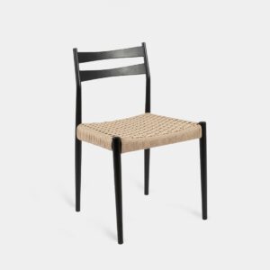 La silla de comedor Vina combina la robustez de la madera de haya en color negro con la calidez del asiento de cuerda. Su diseño minimalista destaca la belleza de los materiales naturales